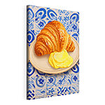 Stampa su tela Un croissant e un liquido giallo su un piatto